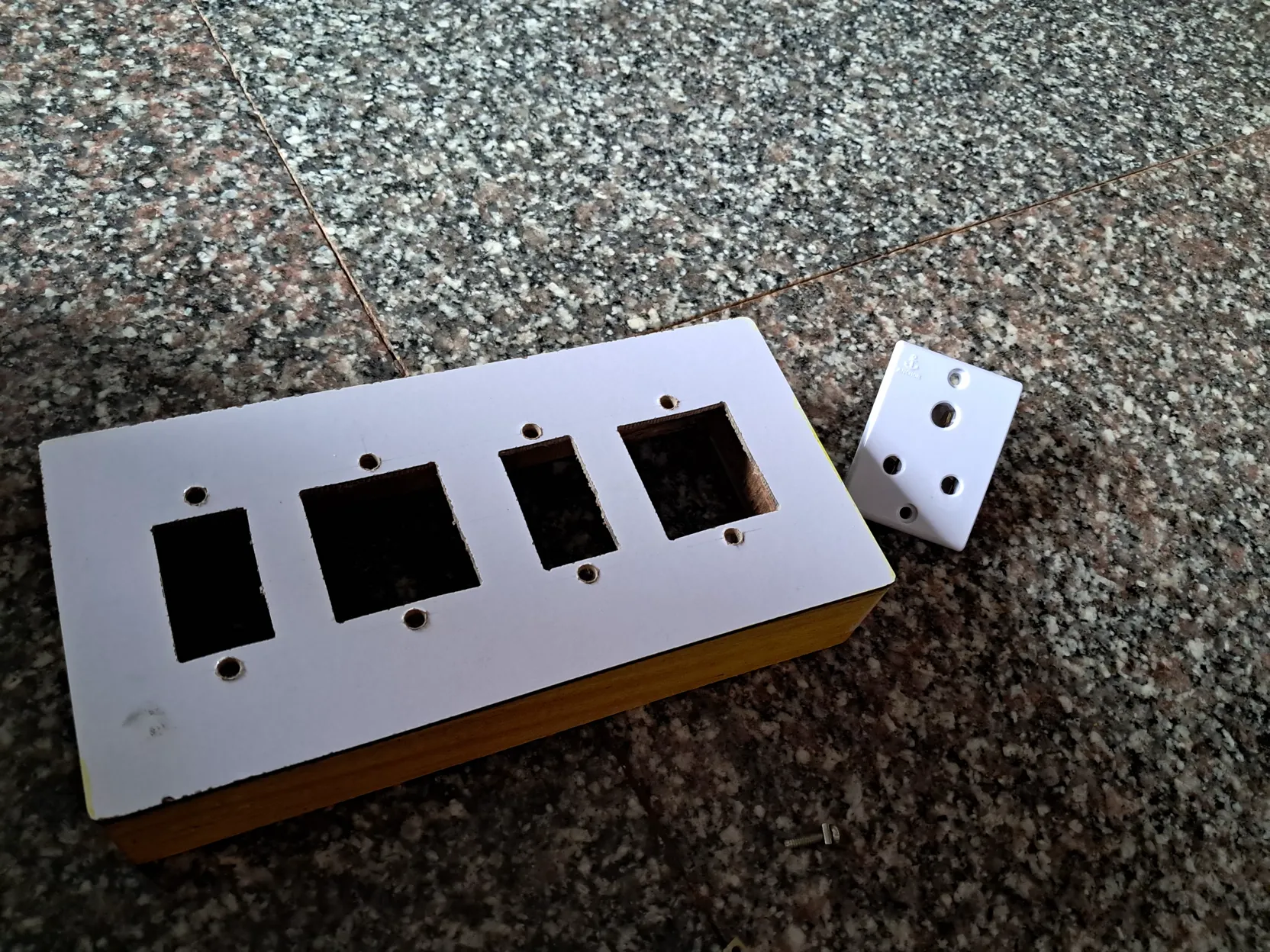Wooden enclosure cut for four switch and socket modules